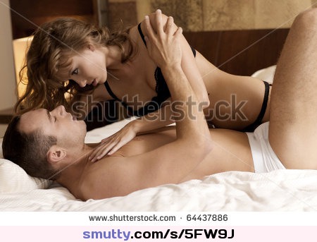 intimate young couple during foreplay in bed