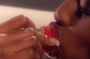 Wet juicy ebony lips playing with strawberry